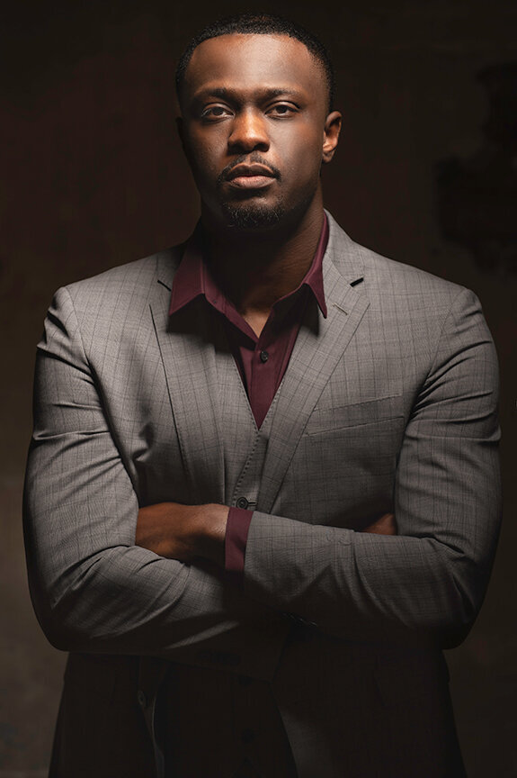 Executive headshot of a man in a gray suit against a dark background