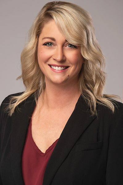 Corporate headshot of a blonde professional in a dark blazer