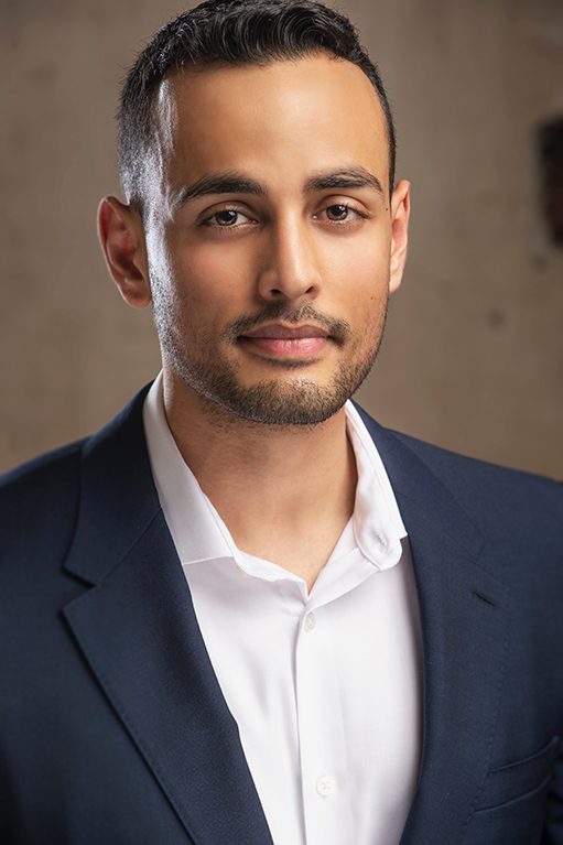Executive headshot of a man in a navy suit and white shirt