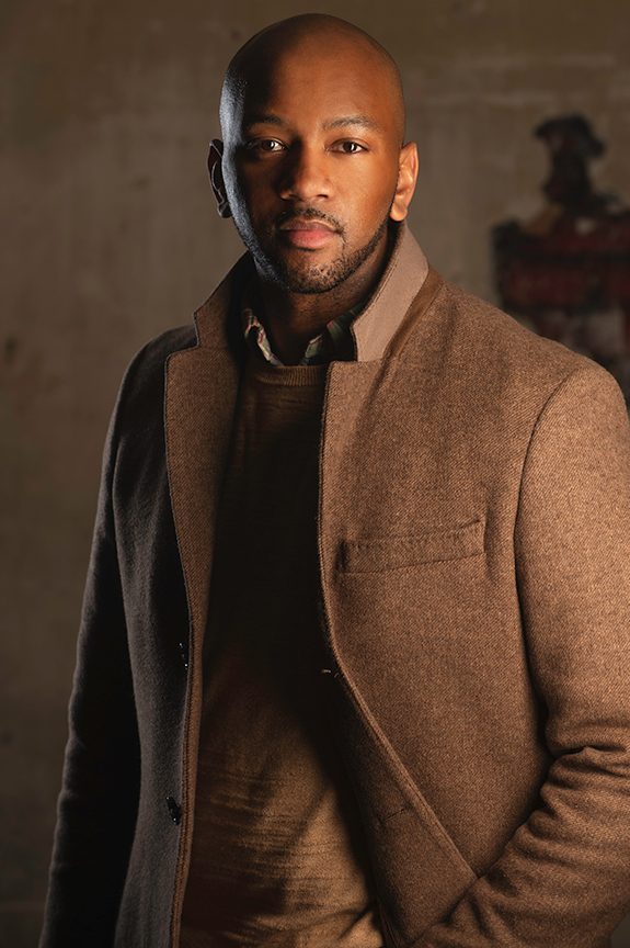 Business owner in a brown overcoat against a warm textured background