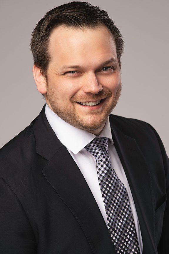 Smiling professional in a gray suit and blue tie