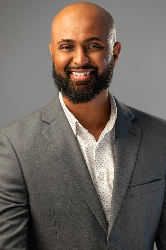 Executive in a dark suit with a gold tie and pocket square