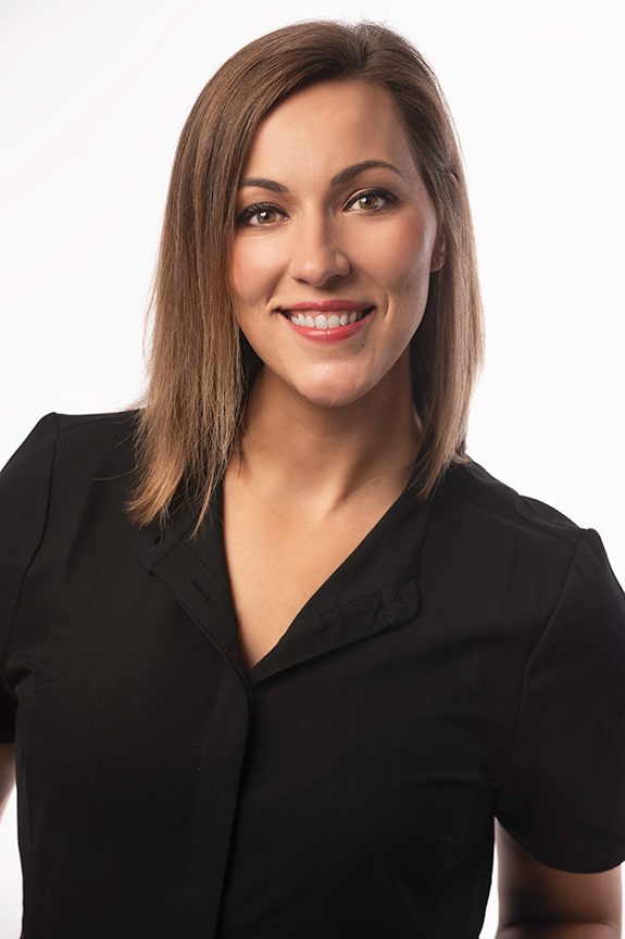 Healthcare professional in a black top against a neutral background